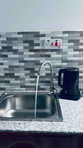a kitchen sink with a faucet on a counter at Osim bnb 2 in Arusha