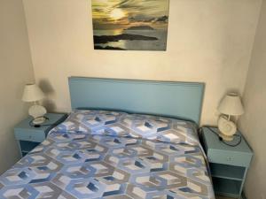 a bedroom with a bed with two nightstands and two lamps at Azzurrina in Marettimo