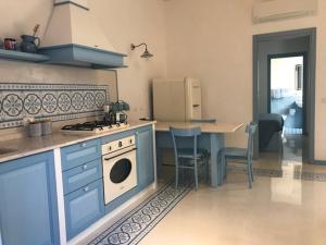 a kitchen with blue cabinets and a stove and a table at Azzurrina in Marettimo