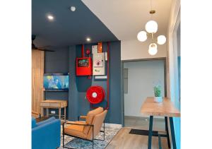 a living room with blue walls and a table and chairs at Hotel Double Star Klia in Sepang