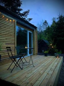 a patio with two chairs and a table on a deck at Hulen - Ro & Natur in Bindslev