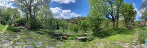 a garden with a stone fence and trees and grass at The Village in Anzat-le-Luguet