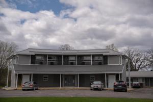 a building with two cars parked in front of it at Aquarius Motel in Perth