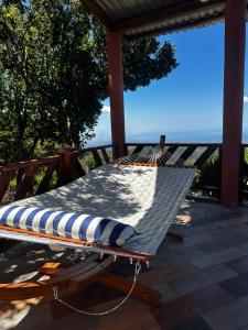 a hammock on a deck with a view of the ocean at Xitlaly cabins in La Montaña +45 photos