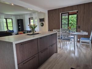 a kitchen and living room with a table and chairs at Stenberg Nature Residence in Tyringe