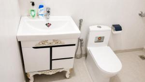a bathroom with a white sink and a toilet at The Onyx by 7 Valleys in Islamabad +7 photos