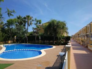 a swimming pool next to a building with palm trees at Casa Althaya in Alcalà de Xivert