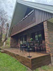 a wooden deck with a table and chairs on it at Stenberg Nature Residence in Tyringe