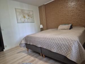a bedroom with a bed and a painting on the wall at Stenberg Nature Residence in Tyringe