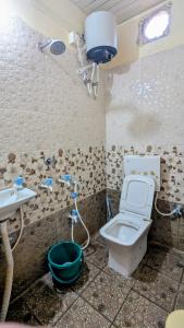 a dirty bathroom with a toilet and a sink at KSHIPRA GUEST HOUSE in Ujjain