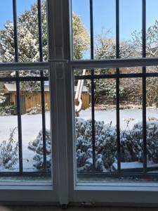 a window view of a snow covered yard at Entzückendes Studio in historischer Villa in Aschau