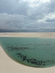 a beach with a body of water in the sand at Lardunas in Santo Amaro