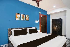 a bedroom with a large bed with a blue wall at Hotel Sundari in Guwahati