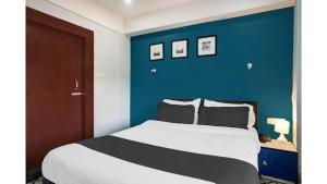 a bedroom with a large bed with a blue wall at Hotel Sundari in Guwahati +7 photos