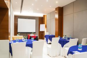 a conference room with blue tables and white chairs at Udman Hotel Panchshila Park in New Delhi
