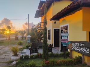 a building with chairs and a sign in front of it at Pousada Dos Girassois Prado in Prado