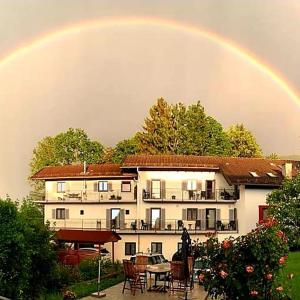 a rainbow in the sky above a building at Kurbad St Martin in Bad Kohlgrub