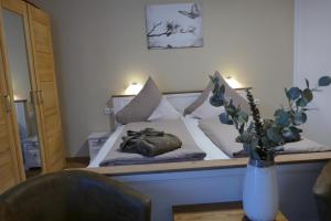 a bedroom with a bed with a vase of flowers at Kurbad St Martin in Bad Kohlgrub