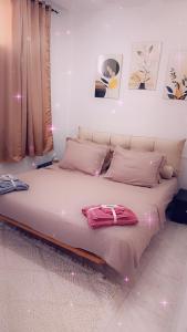 a large bed in a room with pink lights at appart kelibia a 10 minutes d une belle plage el fatha in Kelibia