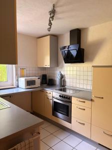 a kitchen with a stove and a microwave at Gemütliche 3-Zimmer-Wohnung mit Kupfertalblick in Forchtenberg +14 photos