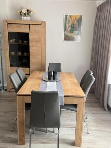 a dining room with a wooden table and chairs at Mieszkanie - Apartament in Dąbrowa