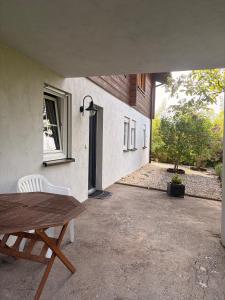a patio with a wooden table and a window at Gemütliche 3-Zimmer-Wohnung mit Kupfertalblick in Forchtenberg