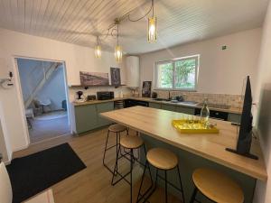 a kitchen with a counter and stools in it at House in forest proche GR and circuit in Saint-Mars-la-Brière