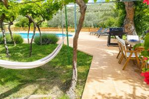 a hammock hanging from a tree next to a pool at Cortijo El Búho - Casa rural con piscina privada en Montefrío in Montefrío