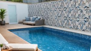 a swimming pool in a living room with a tile wall at Nivasole Lara Pure Comfort & Style in Antalya