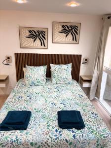 a bedroom with a bed with two blue pillows at Studio 2 neuf RDC hyper centre-ville in Bar-le-Duc