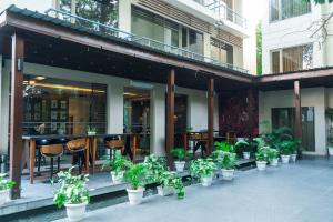 a patio with potted plants and a restaurant at Udman Hotel Panchshila Park in New Delhi