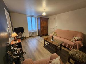 a living room with a couch and a table at La maison de preuillé in Payré