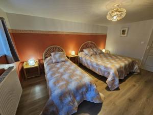a bedroom with two beds and two tables with lamps at La maison de preuillé in Payré