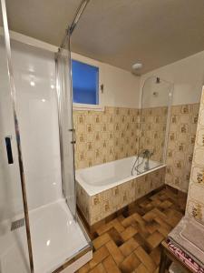a bathroom with a bath tub and a shower at La maison de preuillé in Payré +9 photos