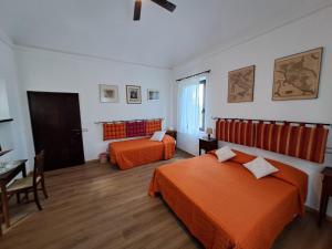 a bedroom with two beds and a table and a desk at Azalea Guest House in Siena +55 photos