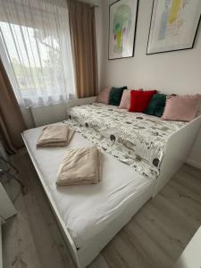 a bed with two pillows on it in a room at Mieszkanie - Apartament in Dąbrowa