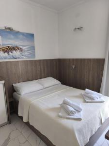 a white bed with towels on top of it at Apartments Sun Dance 2 with heated Pool in Novalja +20 photos
