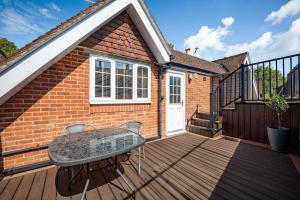 a patio with a table on a wooden deck at Comfortable Cottage with Decking in Castle Cary in Castle Cary