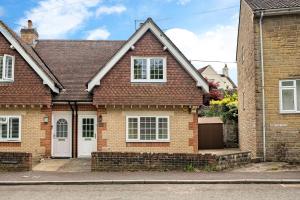 a brick house with a white door on a street at Comfortable Cottage with Decking in Castle Cary in Castle Cary