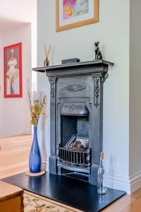 a fireplace in a living room with a blue vase at Comfortable Cottage with Decking in Castle Cary in Castle Cary