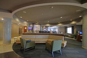 a lobby with a waiting area with chairs and a bar at SpringHill Suites by Marriott Charleston North in Charleston