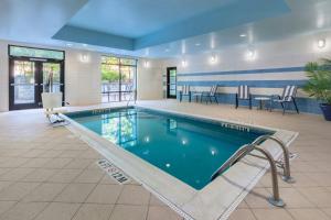 a swimming pool with chairs and tables in a building at SpringHill Suites by Marriott Charleston North in Charleston