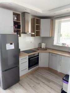 a kitchen with white cabinets and a stainless steel refrigerator at Mieszkanie - Apartament in Dąbrowa +9 photos