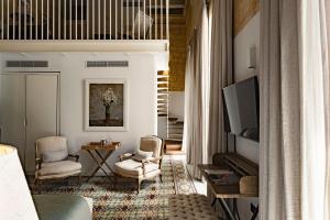 a living room with a television and two chairs at 66 Saint Paul's & Spa in Valletta