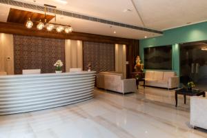 a lobby with a waiting room with chairs and a counter at Hotel Avenue 30 in Lucknow