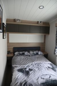 a bed with two dogs laying on top of it at Wild Thistle static Caravan in Kirkcolm +30 photos
