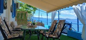 a table and chairs on a balcony with a view of the ocean at Sotirias Beach House in Kalamos