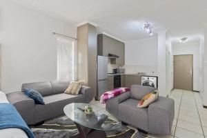 a living room with two couches and a table at Spacious Studio Fourways Sandton - Self Check-in in Sandton