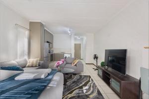 a living room with a couch and a tv at Spacious Studio Fourways Sandton - Self Check-in in Sandton