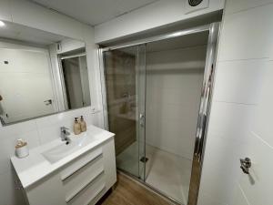 a white bathroom with a shower and a sink at Oasis Cordobés in Córdoba +53 photos